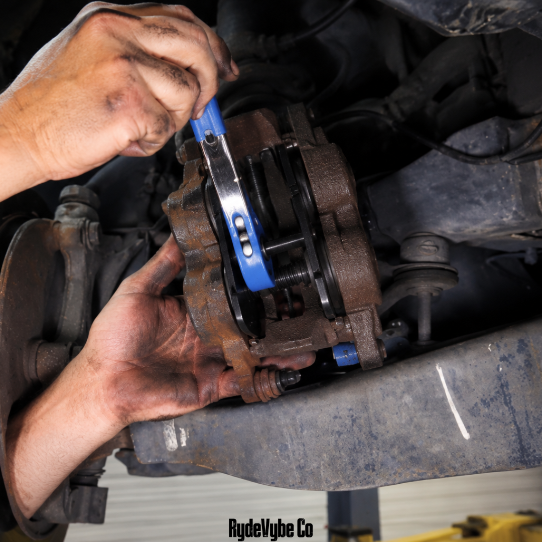Person working on a car brake system with tools
